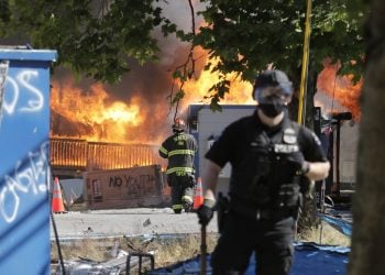 抗議者在7月25日點燃了西雅圖青少年距離中心附近的建築 (AP Photo/Ted S. Warren)