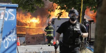 抗議者在7月25日點燃了西雅圖青少年距離中心附近的建築 (AP Photo/Ted S. Warren)